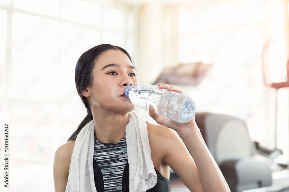 Pretty sporty young asian woman drinking water after sport training workout Pretty sporty young asian woman drinking water after sport training workout
