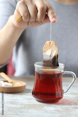 dipping a tea bag into a glass