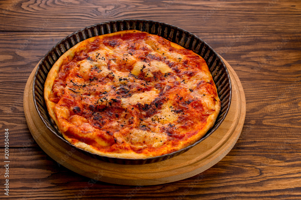 Appetizing Homemade Pizza with cheese on a wooden background Appetizing Homemade Pizza with cheese on a wooden background