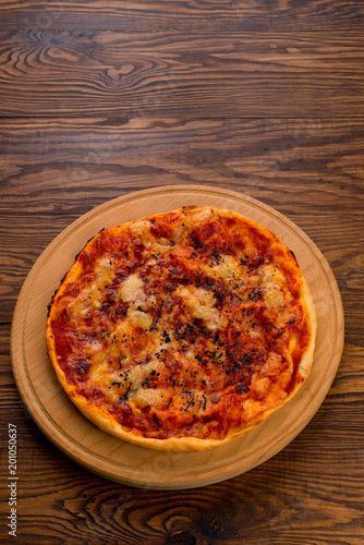 Appetizing Homemade Pizza with cheese on a wooden background