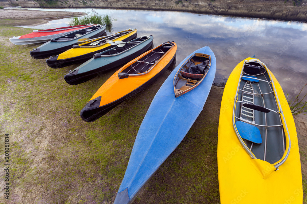 collection of colorful kayaks on riverside at summer day collection of colorful kayaks on riverside at summer day