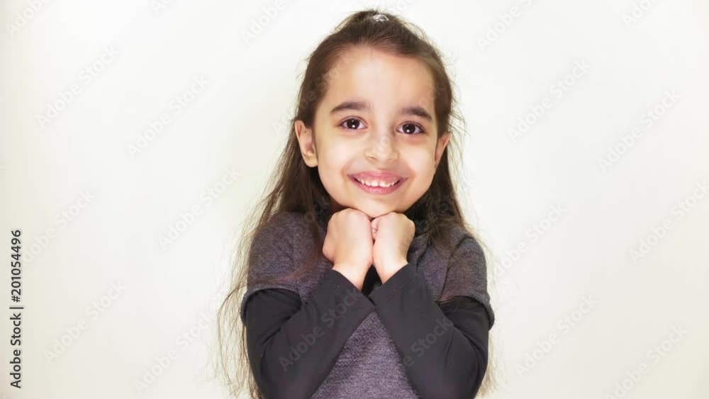 Little cute caucasian girl looks at the camera, smiling and then makes a sad face, white background 50 fps Little cute caucasian girl looks at the camera, smiling and then makes a sad face, white background 50 fps