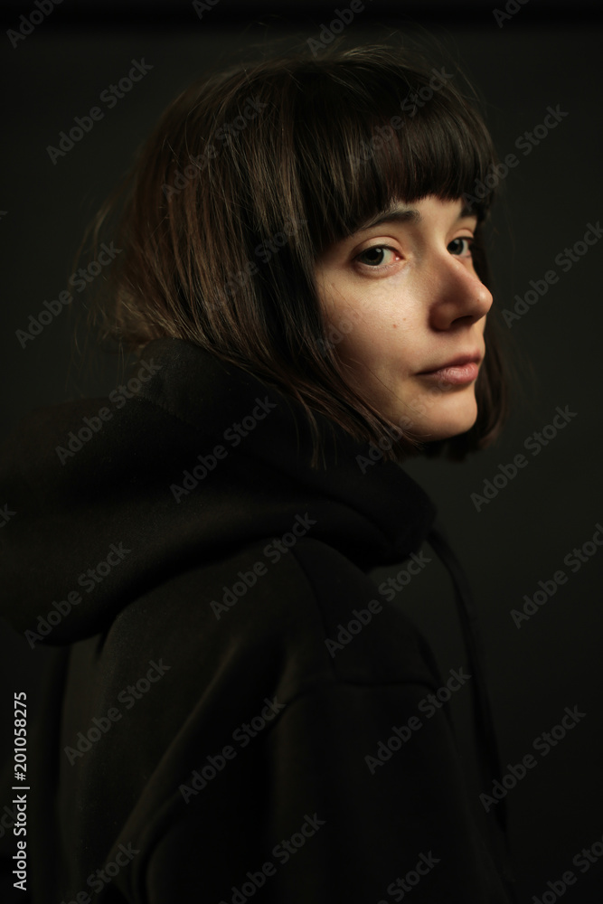 Portrait of young brunette with short hair and bob haircut, without make up, wearing black hoodie, looking over shoulder, isolated on black background Stock Photo | Adobe Stock Portrait of young brunette with short hair and bob haircut, without make up, wearing black hoodie, looking over shoulder, isolated on black background Stock Photo | Adobe Stock