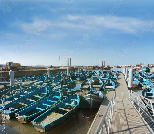 Many blue wooden boats in a harbor