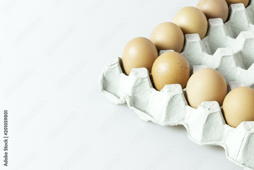 Raw chicken eggs in paper  container on isolated background.
