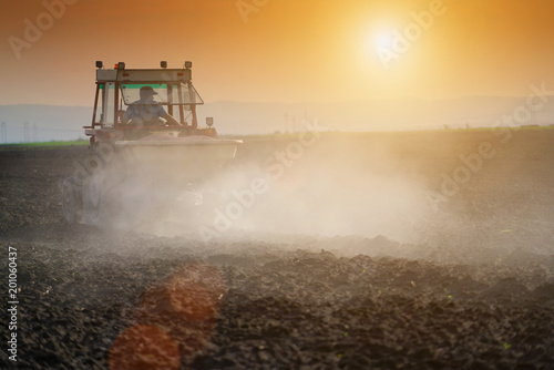 Farmer plowing field in tractor with seed bed