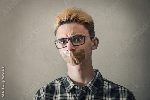 ragazzo con il nastro adesivo per pacchi sulla bocca