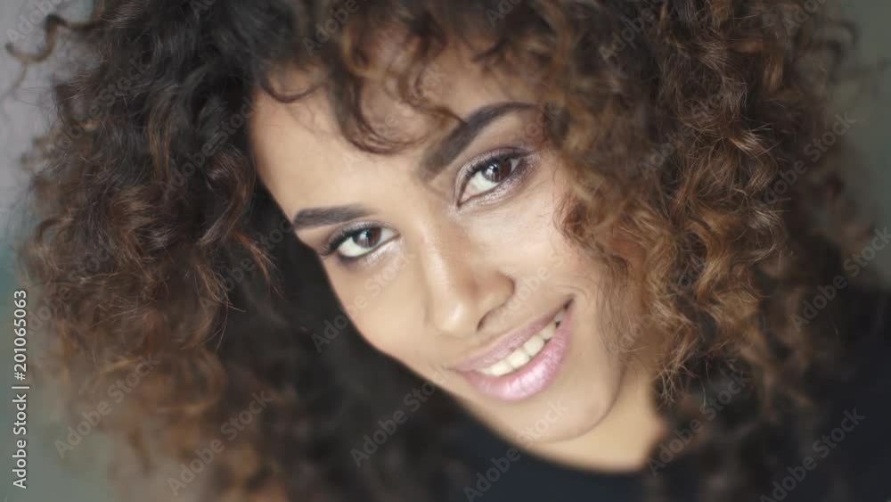 curly girl turns and looks at the camera. close-up portrait curly girl turns and looks at the camera. close-up portrait