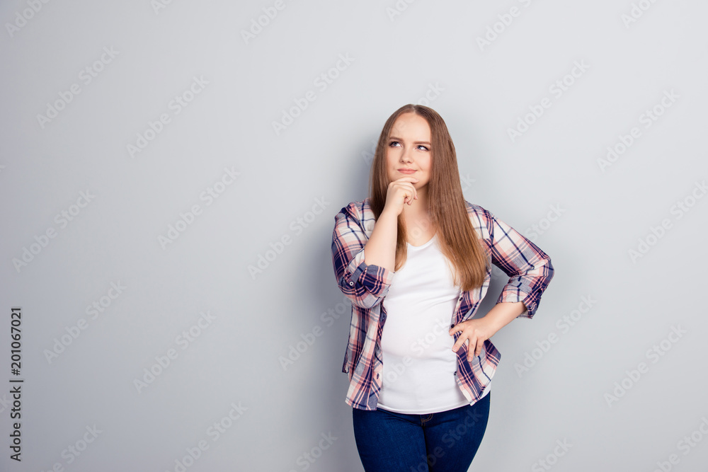 Young woman in flannel shirt holds chin with hand Young woman in flannel shirt holds chin with hand