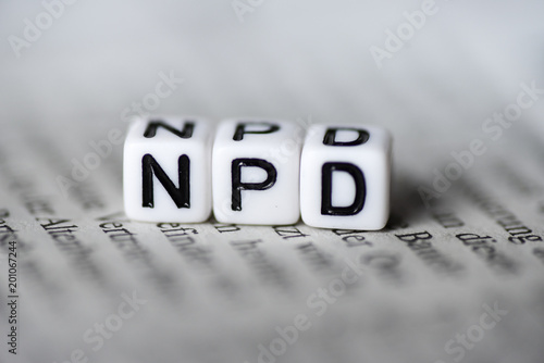 Word NPD formed by wood alphabet blocks on newspaper german party politics