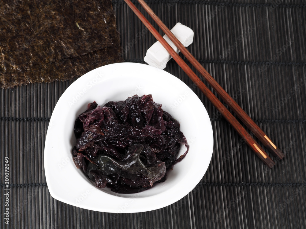 Nori Seaweed – Alga Nori Edible seaweed of the red algae. Binomial name:  Porphyra Umbilicalis. It is used in dried sheets to wrap the sushi. Stock  Photo