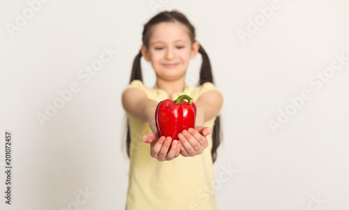 Quadro su tela Pretty cute little girl with bell pepper over white background