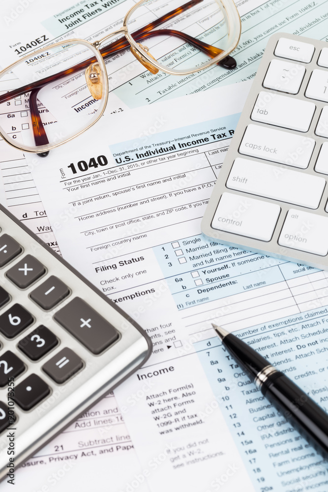Tax form with calculator, pen, glasses, and keyboard Tax form with calculator, pen, glasses, and keyboard