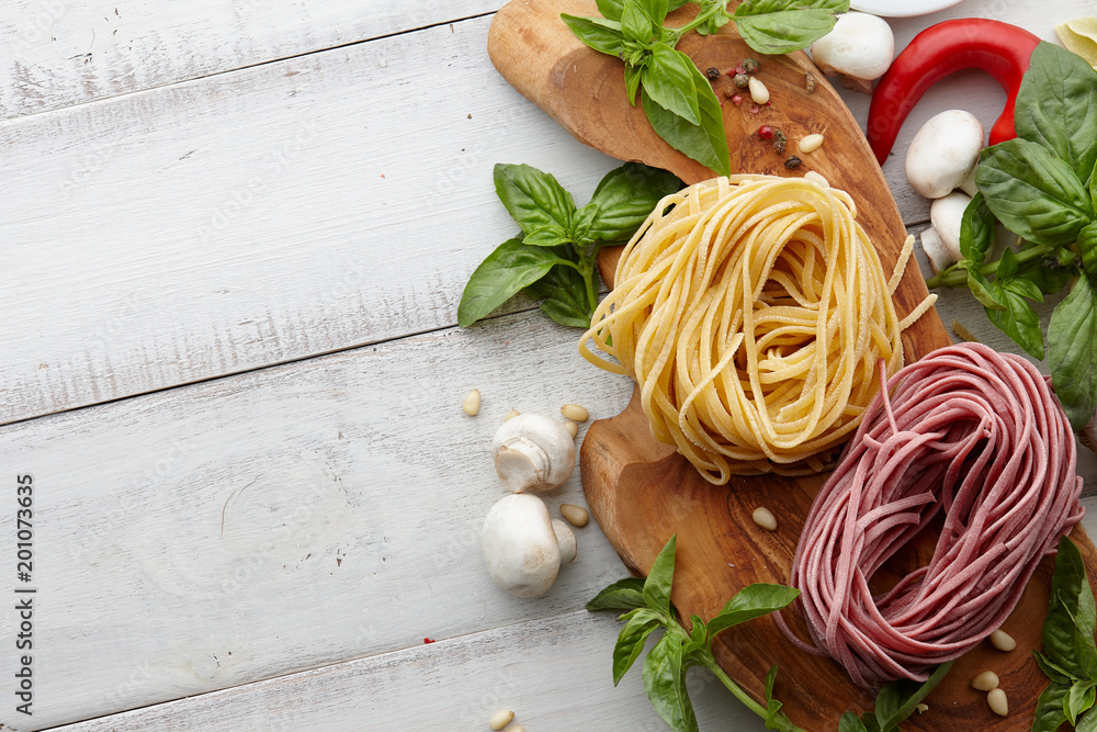 Wunschmotiv: Raw homemade italian pasta and ingredients on white wooden background, cooking process