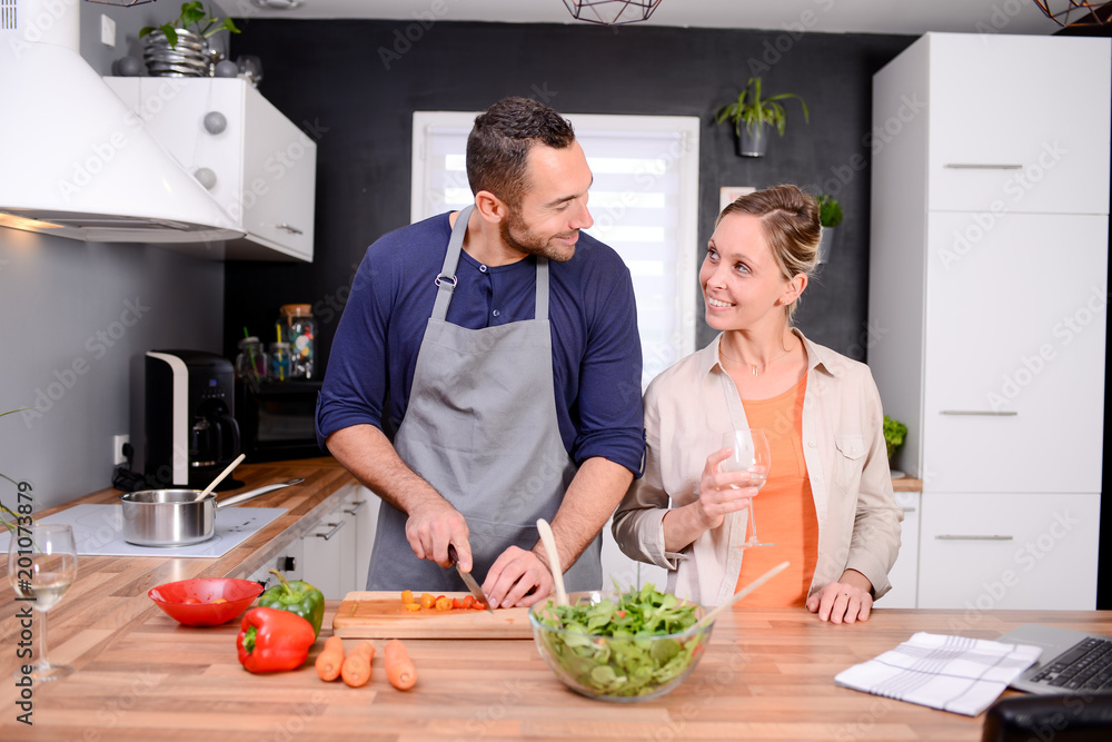 happy and cheerful young couple cooking organic vegetables together at home happy and cheerful young couple cooking organic vegetables together at home