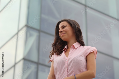 Young beautiful caucasian business woman standing near the corporate center