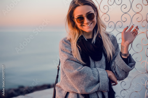 Portrait of woman wearing sunglasses and winter coat looking at camera smiling, Odessa, Odeska Oblast, Ukraine, Eastern Europe photo