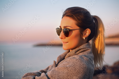 Portrait of woman with ponytail wearing sunglasses looking away smiling, Odessa, Odeska Oblast, Ukraine, Eastern Europe photo