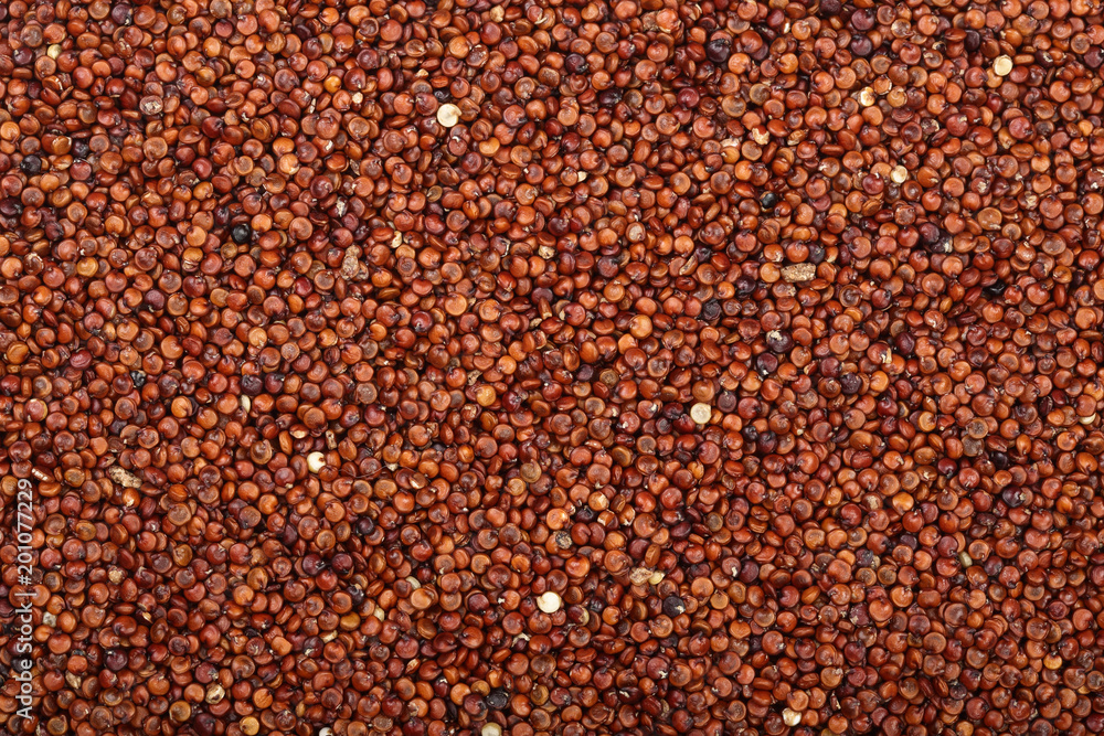 red quinoa seeds as a background. Top view