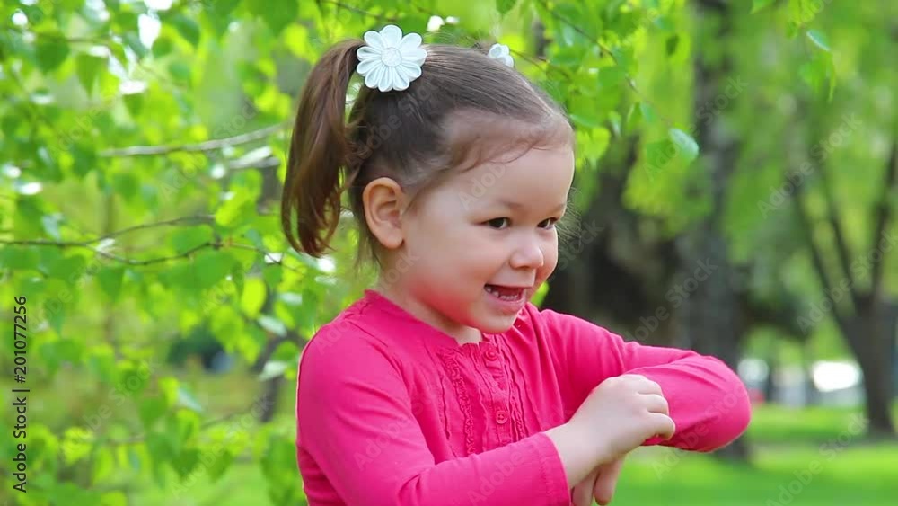 Adult mother tickles her shy 4 years old little daughter while playing outdoors in green spring or summer park. Adult mother tickles her shy 4 years old little daughter while playing outdoors in green spring or summer park.