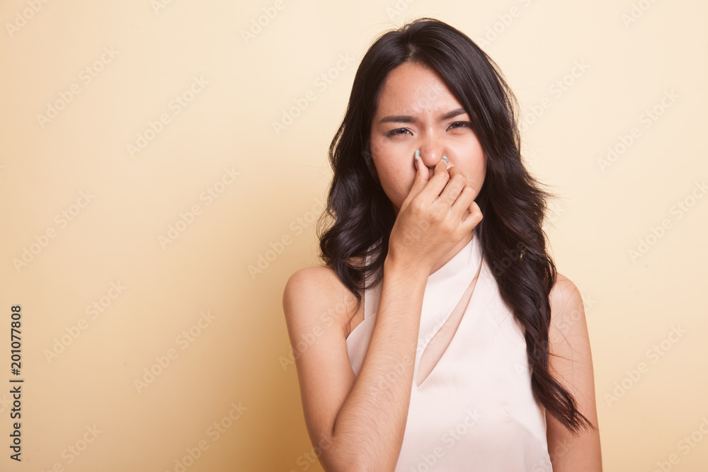 Young Asian woman holding her nose because of a bad smell. Young Asian woman holding her nose because of a bad smell.