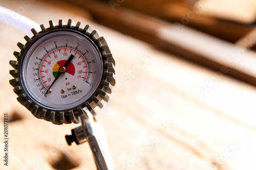 Manometer close up shot , blurry used oak workbench in the background .