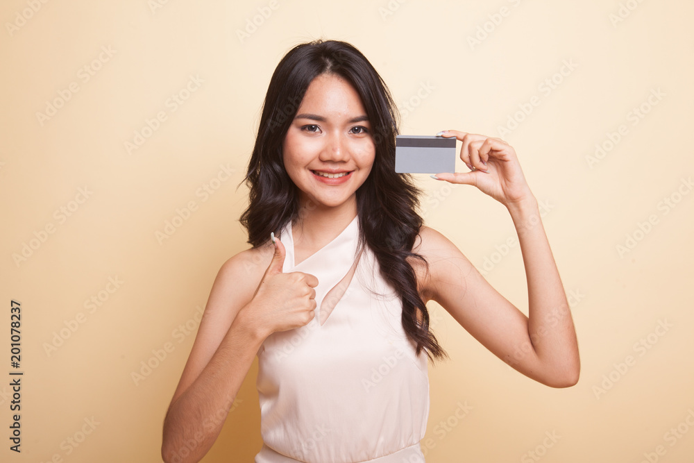 Fototapeta premium Young Asian woman thumbs up with a blank card.