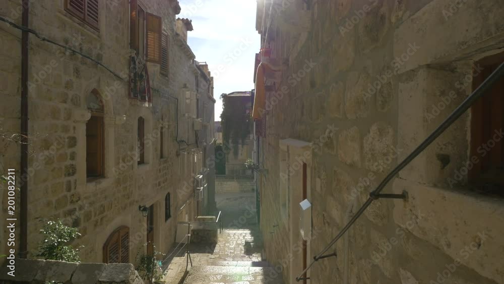 A narrow street between stone buildings A narrow street between stone buildings
