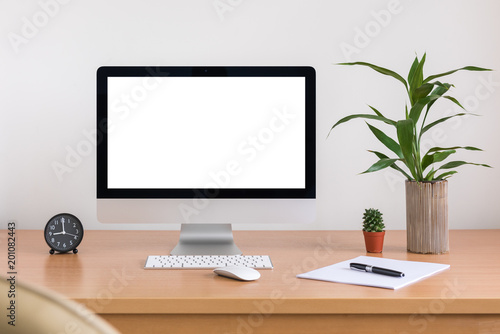 All in one computer, mouse, keyboard, paper, pen, cactus and tree vase  on wooden table