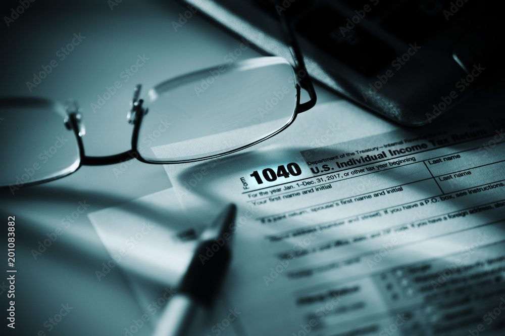 tax form with pen calculator and glasses ** Note: Shallow depth of field tax form with pen calculator and glasses ** Note: Shallow depth of field