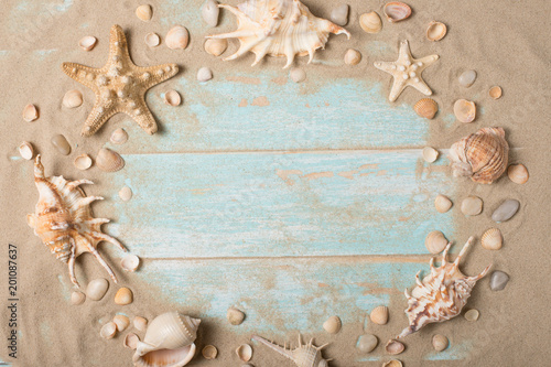 Starfish and seashells with sand on a wooden background. Top view with empty place for inscription