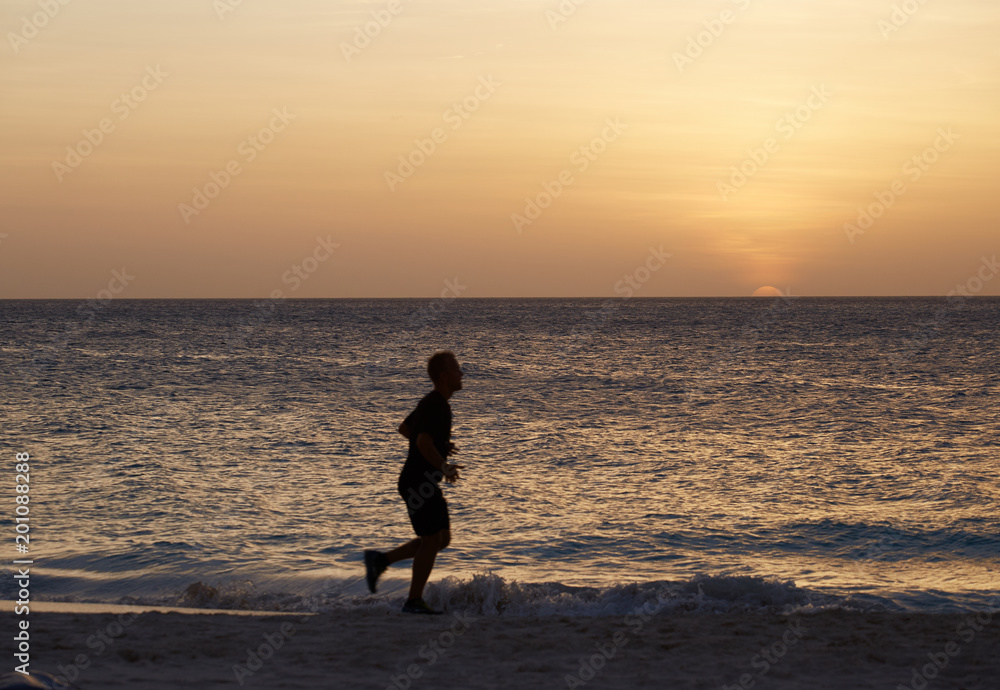 Runner on the beach at sunset
