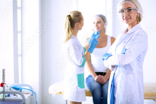Beautiful woman face near doctor with syringe