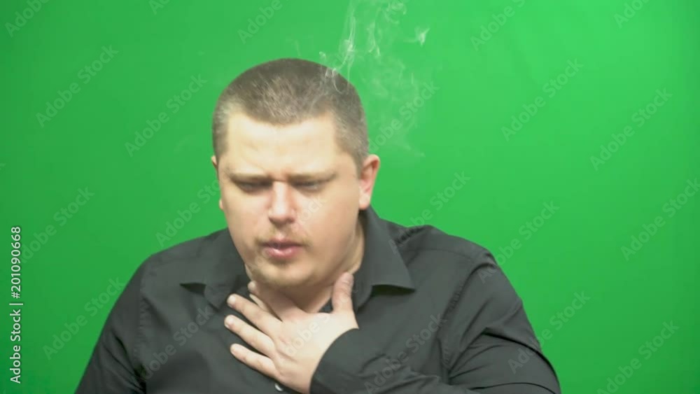 A young man uses an electronic cigarette. Impaired breathing. A young man uses an electronic cigarette. Impaired breathing.