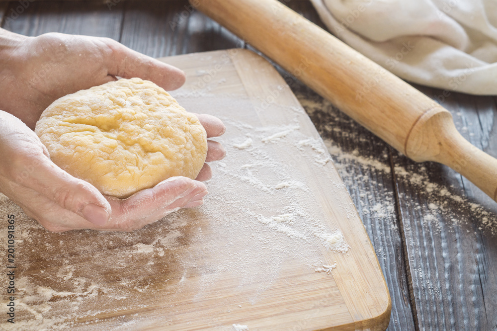 Woman kneading a dough on a table Woman kneading a dough on a table