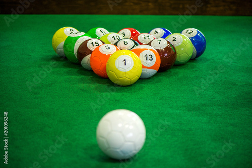 Shot of foot pool balls standing on green table. Foot Pool is the hybrid combination of pool and soccer. Big billiard balls.  photo