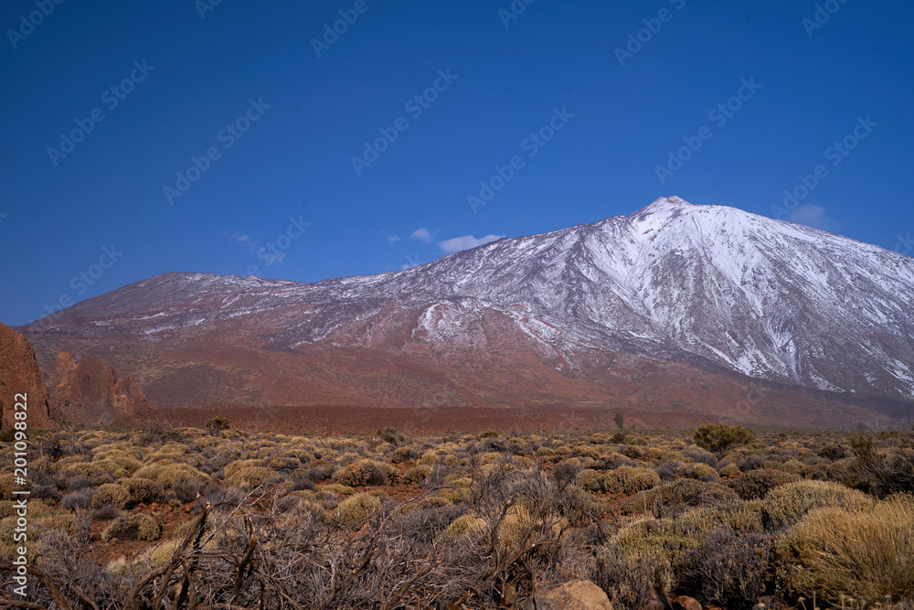 The peak of Teida volcano covered with snow. Lava and snow