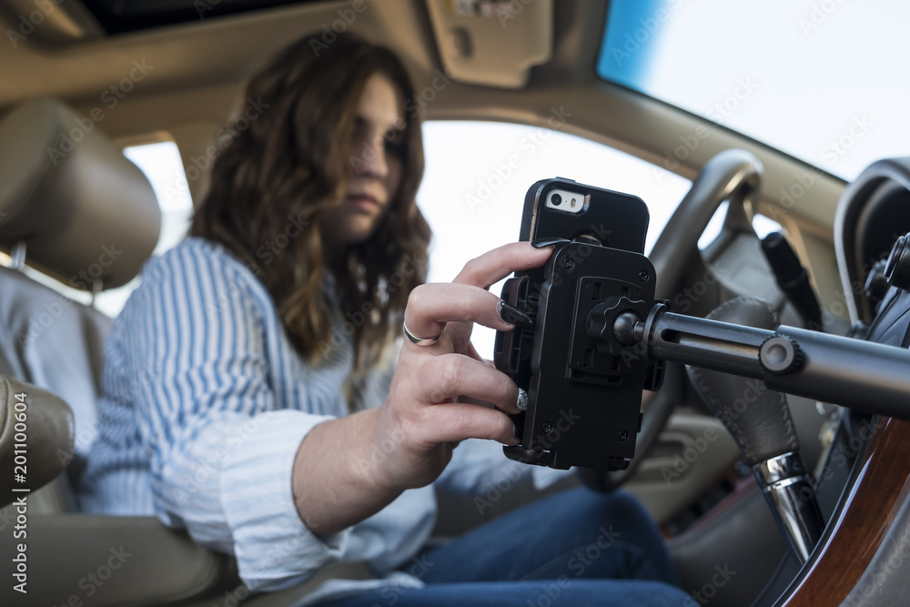 Young woman distracted with cell phone while driving a car