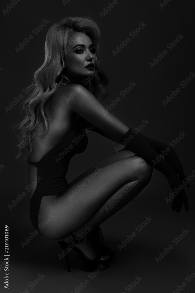 Fototapeta premium black and white photo of a girl in a swimsuit on a dark background.