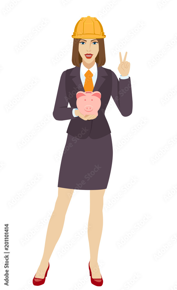 Businesswoman in construction helmet holding a piggy bank and showing victory sign. Two finger up Businesswoman in construction helmet holding a piggy bank and showing victory sign. Two finger up