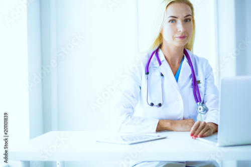 Portrait of three confident female doctors standing with arms crossed at the medical office.