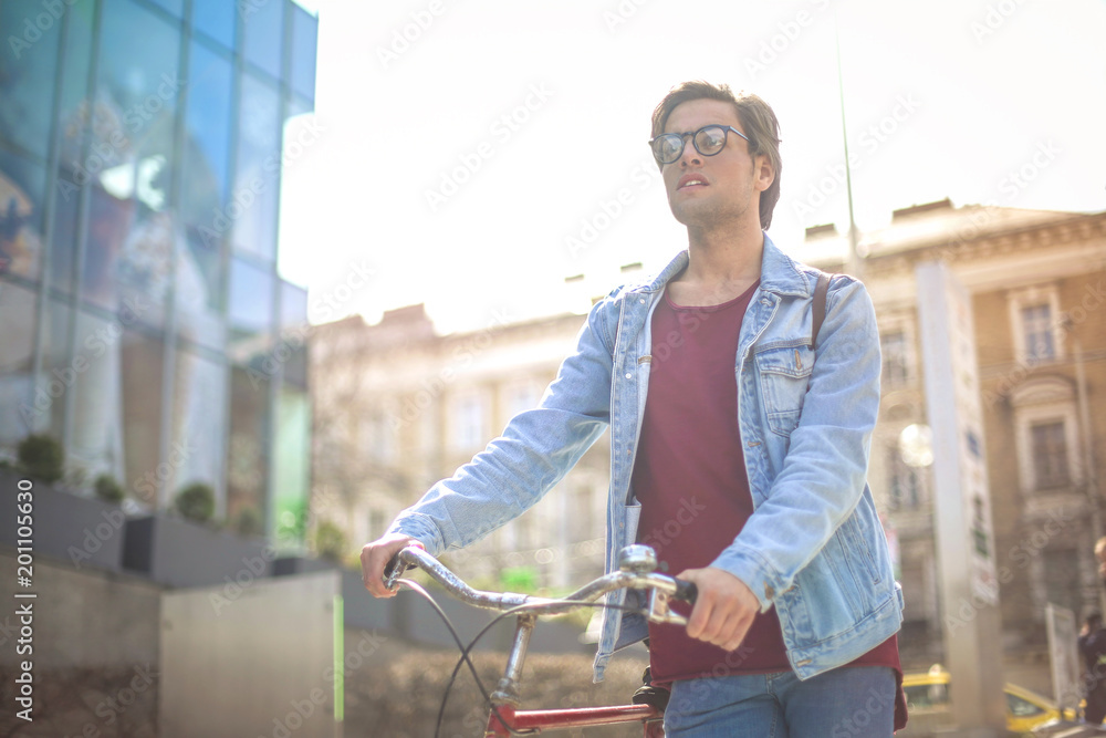 Guy walking around holding a bike on his side