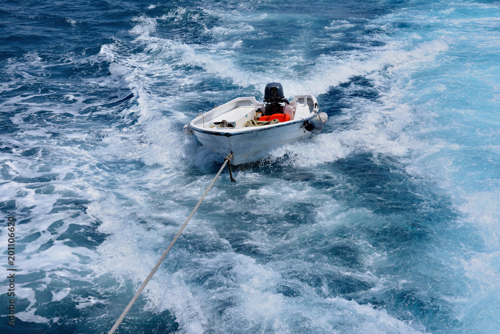 Fototapeta premium empty boat on a rope in the open sea