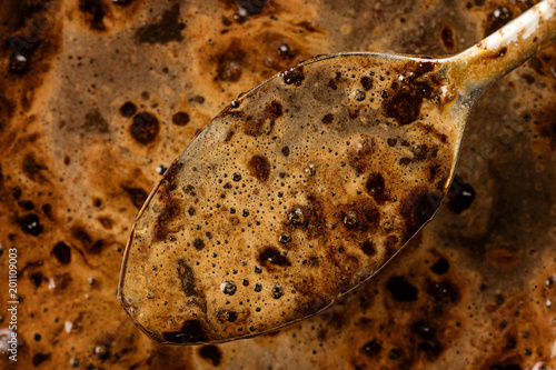Spoon of dark strong coffee...