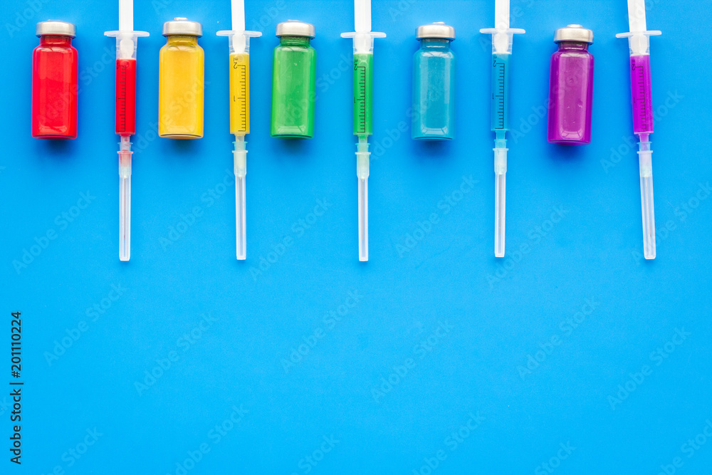 Medical injection. Syringe and bottle with remedy on blue background top view copy space Medical injection. Syringe and bottle with remedy on blue background top view copy space