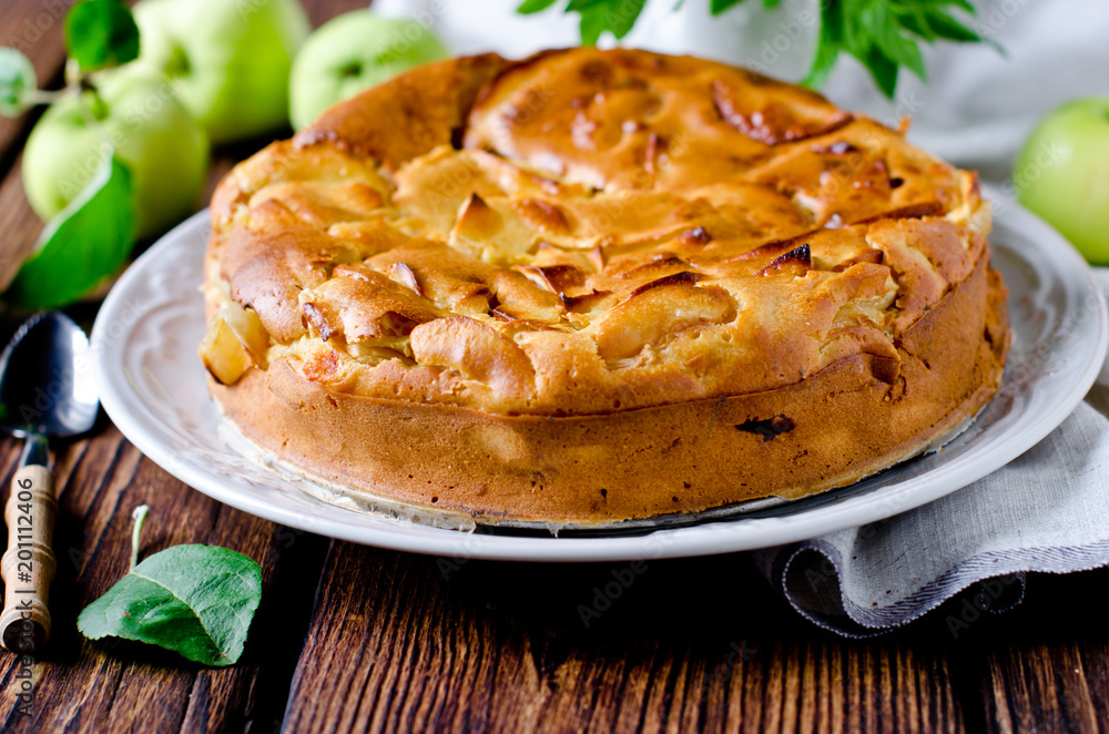 Apple cake on the plate on a wooden table