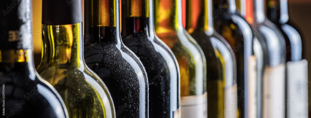Line of wine bottles. Close-up. - obrazy, fototapety, plakaty 