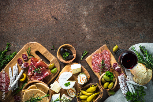 Antipasto delicatessen - meat, cheese, olives and wine on stone  photo