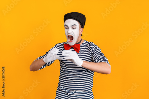 Mime man open mouth and eating big imaginarium hamburger photo