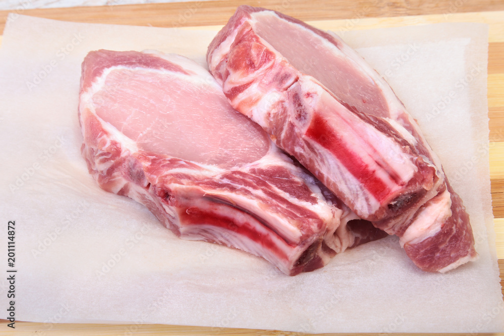Raw pork chops, spices on cutting board. Ready for cooking. Raw pork chops, spices on cutting board. Ready for cooking.
